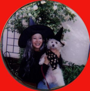 A pet owner and her dog each dressed as Halloween witches